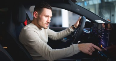 
					  Felix B�llmann, Customer Onboarding f�r Digitale Extras bei Mercedes-Benz, sitzt auf dem Fahrersitz eines Mercedes-Benz CLA und bedient mit der rechten Hand den Zentralbildschirm.
					  