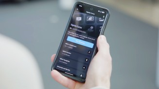 
Blick auf ein Smartphone, das Felix B�llmann in der rechten Hand h�lt, die Digitalen Extras in der Mercedes-Benz App sind ge�ffnet und der Button &bdquo;Alle aktivieren&ldquo; ist zu erkennen.
