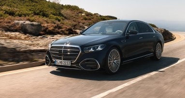 
					  Die neue S-Klasse in MANUFAKTUR schwarz sparkling f�hrt auf einer kurvenreichen Stra�e. Das Fahrzeug ist aus einer schr�gen Frontperspektive zu sehen, mit klar erkennbarer Frontpartie, Chromdetails und Mercedes-Stern auf der Motorhaube.
					  