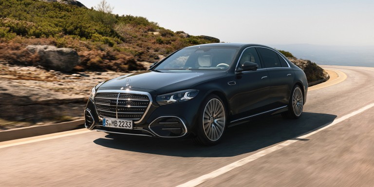 
				Die neue S-Klasse in MANUFAKTUR schwarz sparkling f�hrt auf einer kurvenreichen Stra�e. Das Fahrzeug ist aus einer schr�gen Frontperspektive zu sehen, mit klar erkennbarer Frontpartie, Chromdetails und Mercedes-Stern auf der Motorhaube.
				