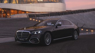 
Die neue S-Klasse in MANUFAKTUR black sparkling steht vor dem Mercedes-Benz Museum. Das Fahrzeug ist aus einer schr�gen Front- und Seitenperspektive zu sehen, mit beleuchtetem K�hlergrill, markanter Lichtsignatur und spiegelnden Oberfl�chen im Abendlicht.
