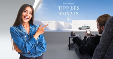 
					  Eine br�nette Frau auf der linken Seite deutet mit dem Zeigefinger in die andere Bildh�lfte. Dort befindet sich ein Mann, der ein Smartphone h�lt. Auf dem Bildschirm ist der Konfigurator von Mercedes-Benz Members zu sehen. In der oberen H�lfte des Bildes steht &bdquo;Mercedes-Benz Members Tipp des Monats&ldquo;, darunter ist der Mercedes-Stern abgebildet.
					  