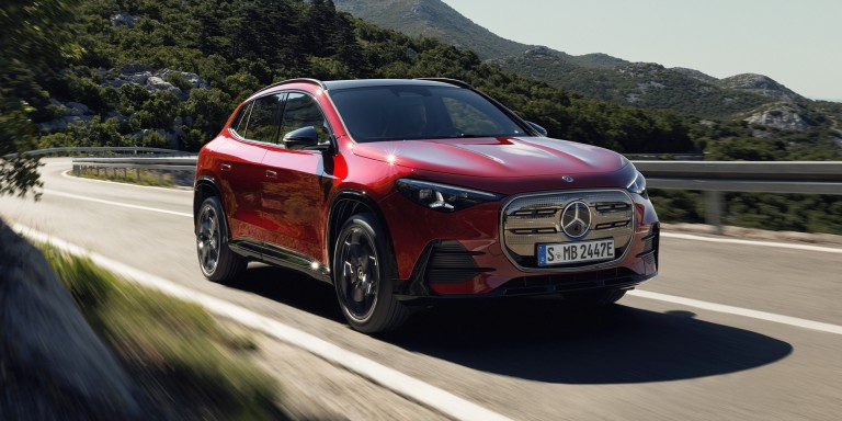 
				Der neue elektrische Mercedes-Benz GLA in der Farbe MANUFAKTUR patagonienrot metallic auf einer kurvenreichen Landstra�e in einer bergigen Landschaft. Das Fahrzeug ist aus der Front- und Seitenperspektive zu sehen und f�hrt aus einer Linkskurve. Im Hintergrund sind dicht bewachsene H�gel zu sehen.
				