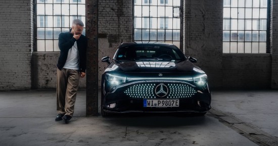 
					  Christopher Hartung steht neben einem elektrischen CLA von Mercedes-Benz in nachtschwarz uni, dessen Frontscheinwerfer erleuchtet sind. Christopher h�lt beeindruckt seine rechte Hand vor den Mund und schaut zum Fahrzeug.
					  