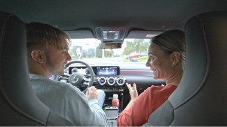 
Blick vom R�cksitz zu Susanne Gutmann, die auf dem Beifahrersitz sitzt, und ihrem Sohn Leon, der am Steuer einer A-Klasse sitzt. Das Fahrzeug steht. Susanne tr�gt ein rostrotes Sweatshirt, ihr Sohn ein graues Sweatshirt. Beide schauen sich w�hrend einer Unterhaltung l�chelnd an, durch die Windschutzscheibe ist unscharf das Mercedes-Benz Kundencenter Sindelfingen zu erkennen.
