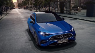 
Der hybride CLA Shooting Brake in Klarblau metallic f�hrt auf einer breiten, nahezu leeren Stra�e durch eine Stadt. Im Hintergrund sind historische Geb�ude, B�ume und eine Haltestelle zu sehen, das Fahrzeug wird frontal aus erh�hter Perspektive gezeigt.
