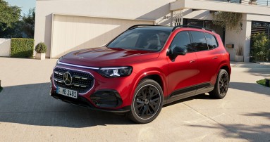 
					  Der neue GLB mit Hybrid-Technologie in MANUFAKTUR patagonienrot metallic steht geparkt vor einer beigefarbenen Garage. Im Hintergrund sieht man neben der Garage rechts einen Hauseingang. Das Fahrzeug ist aus einer leicht schr�gen Frontperspektive zu sehen.
					  