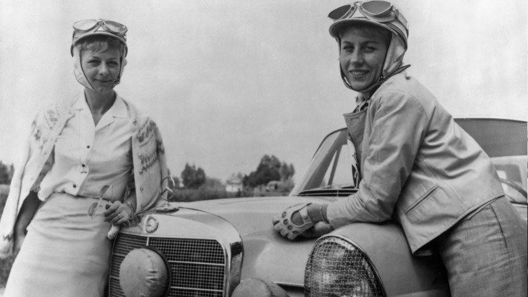 
			Schwarz-Wei�-Aufnahme der beiden Rennfahrerinnen Ewy Rosqvist (rechts) und Ursula Wirth (links), die l�chelnd an der Motorhaube eines Mercedes-Benz Fahrzeugs lehnen.
		