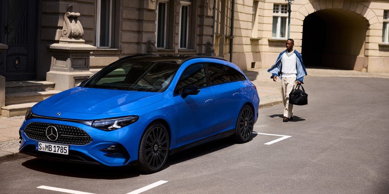 
				Ein CLA Shooting Brake klarblau metallic parkt an einer Stra�e. Die Ansicht zeigt das Fahrzeug aus schr�ger Perspektive von vorne. Ins Auge fallen die klar gezeichnete Frontpartie, die schmalen LED-Leuchten und das dunkle Panoramadach. Ein Mann mit einer Tasche geht von hinten auf das Fahrzeug zu.
				