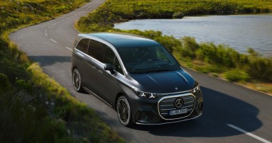 
					  Der elektrische VLE ist von vorne zu sehen und f�hrt auf einer Landstra�e durch eine Landschaft mit gr�nen Wiesen und Bergen im Hintergrund.
					  