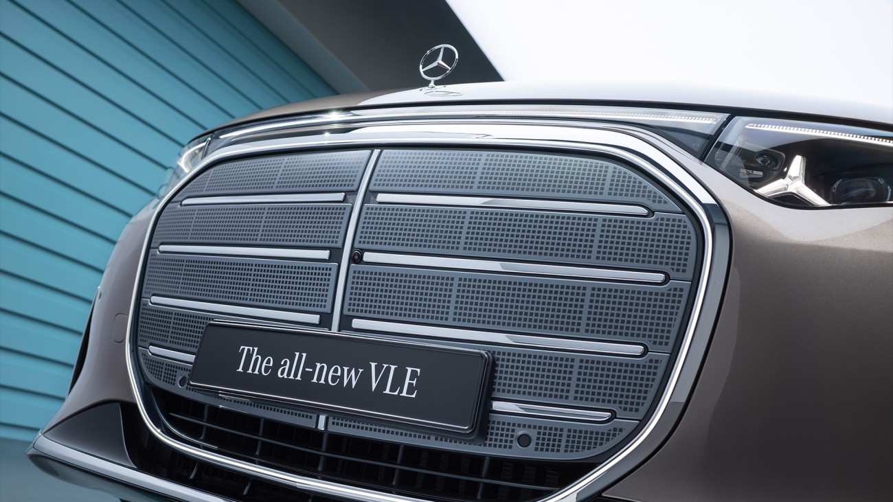 
			Blick auf die Vorderseite des Mercedes-Benz VLE. Auff�llig sind der gro�e K�hlergrill, schmale LED-Scheinwerfer, ein durchgehendes Lichtband sowie die aerodynamisch geformte Motorhaube.
		