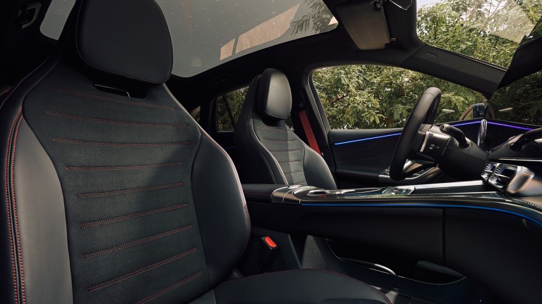 
			Blick in den Innenraum des elektrischen GLC mit dunklen Sitzen, roten Ziern�hten, gro�em Panoramadach und blauer Ambientebeleuchtung.
		