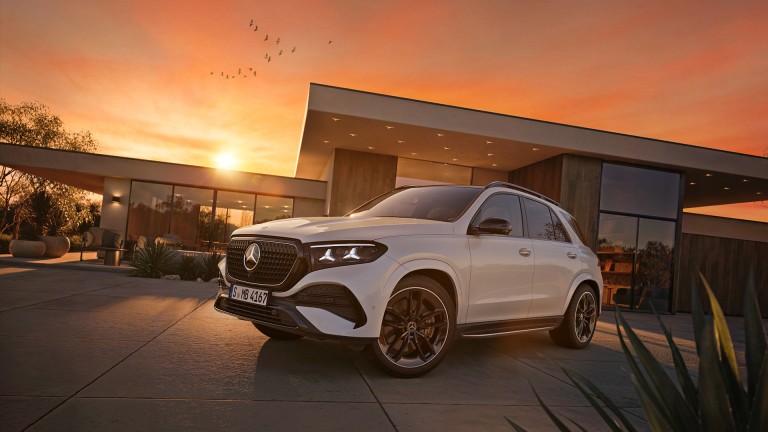 
			Der Mercedes-Benz GLE SUV in seitlicher Frontansicht vor moderner Architektur bei Sonnenuntergang.
		