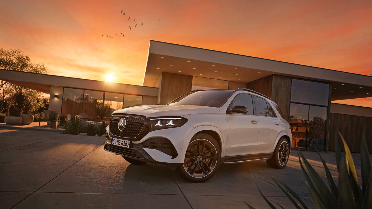 
			Der Mercedes-Benz GLE SUV in seitlicher Frontansicht vor moderner Architektur bei Sonnenuntergang.
		