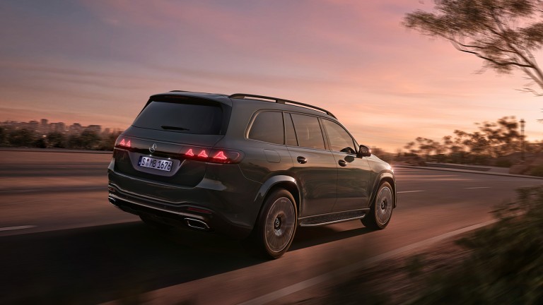 
			Dunkler Mercedes-Benz GLS in Fahrt bei D�mmerung, gezeigt in seitlicher Heckansicht, mit markanter Lichtsignatur und gro�z�gigen Dimensionen.
		