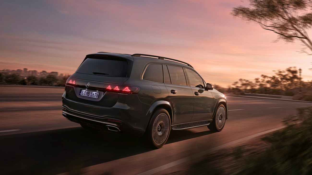 
			Dunkler Mercedes-Benz GLS in Fahrt bei D�mmerung, gezeigt in seitlicher Heckansicht, mit markanter Lichtsignatur und gro�z�gigen Dimensionen.
		