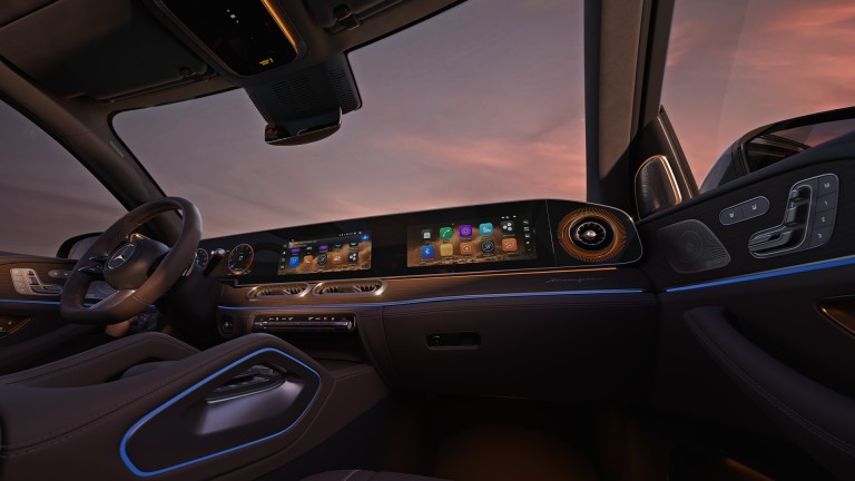
			Cockpit des Mercedes-Benz GLS mit gro�em Display, Ambientebeleuchtung und weitem Blick durch die Frontscheibe bei Abendlicht.
		