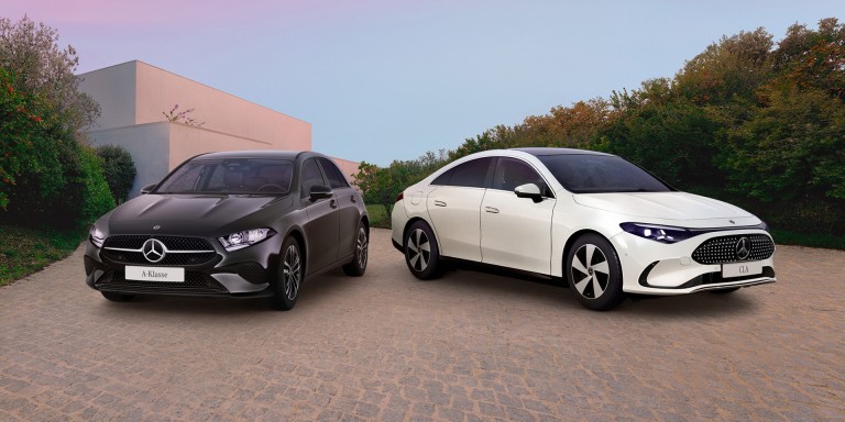 
				Links steht eine schwarze Mercedes-Benz A-Klasse, rechts ein wei�er Mercedes-Benz CLA, aufgenommen auf einem gepflasterten Vorplatz vor moderner Architektur und B�umen.
				