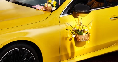 
					  Blick auf die Fahrert�r eines gelben CLE Cabriolets, am Seitenspiegel h�ngt ein kleiner Osterkorb mit Eiern und Blumen, an der Wischerblende steht ein weiterer, kleiner Korb mit Ostereiern und Blumen.
					  