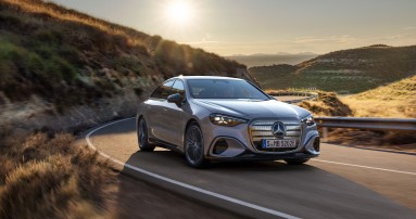 
					  Die neue elektrische Mercedes-Benz C-Klasse in der Lackierung lavender silver metallic in frontaler Ansicht auf einer kurvigen Landstra�e bei tief stehender Sonne. Sichtbar sind der beleuchtete ikonische Grill, die coup�hafte Silhouette und die sportlichen Proportionen vor einer h�geligen Landschaft.)
					  