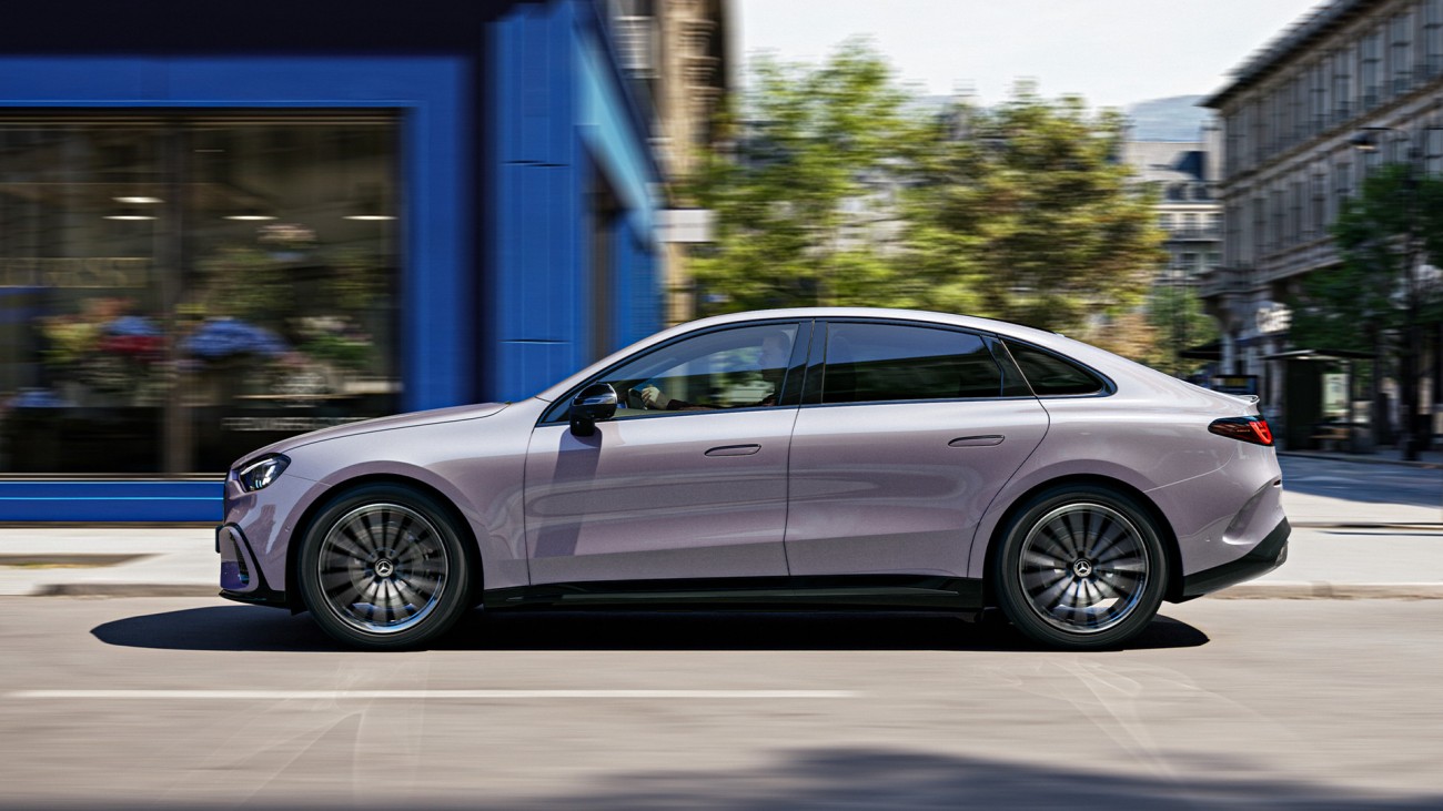 
			Seitliche Ansicht der neuen elektrischen C-Klasse in lavender silver bei der Fahrt durch eine Stadtstra�e. Sichtbar sind die flache Dachlinie, b�ndige T�rgriffe und die lang gestreckte Karosserie.
		
