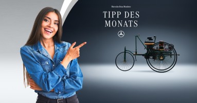 
					  Eine br�nette Frau auf der linken Seite deutet mit dem Zeigefinger in die andere Bildh�lfte. Dort ist in einer Studioaufnahme die linke Seitenansicht einer authentischen Nachfertigung des Patent-Motorwagens von Carl Benz aus dem Jahr 1886 zu sehen. In der oberen H�lfte des Bildes steht &bdquo;Mercedes-Benz Members Tipp des Monats&ldquo;, darunter ist der Mercedes-Stern abgebildet.
					  