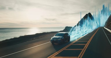 
						  Ein Mercedes-AMG EQS mit MBUX SOUND DRIVE fährt entlang einer Küstenstraße, hinter dem Fahrzeug erheben sich auf der Fahrbahn blaue und abstrakte Animationen, die Soundwellen nachstellen.
						  