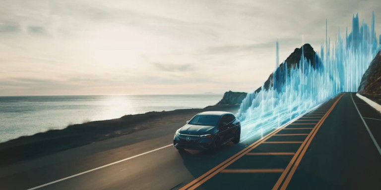 
				Ein Mercedes-AMG EQS mit MBUX SOUND DRIVE fhrt entlang einer Kstenstrae, hinter dem Fahrzeug erheben sich auf der Fahrbahn blaue und abstrakte Animationen, die Soundwellen nachstellen.
				