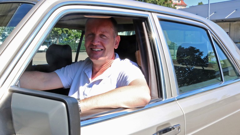 
			Nahaufnahme von Stephan Padinka, der lchelnd am Steuer seines Mercedes-Benz 420 SE sitzt.
		