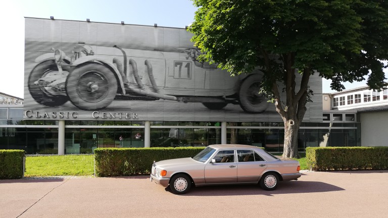 
			Der Mercedes-Benz 420 SE steht vor dem Mercedes-Benz Classic Center.
		