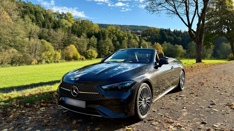 
			Ein schwarzes CLE Cabriolet steht auf einem Feldweg, der von Herbstblttern bedeckt ist. Im Hintergrund sind herbstliche Bume, der blaue Himmel und eine grne Wiese zu sehen.
		
