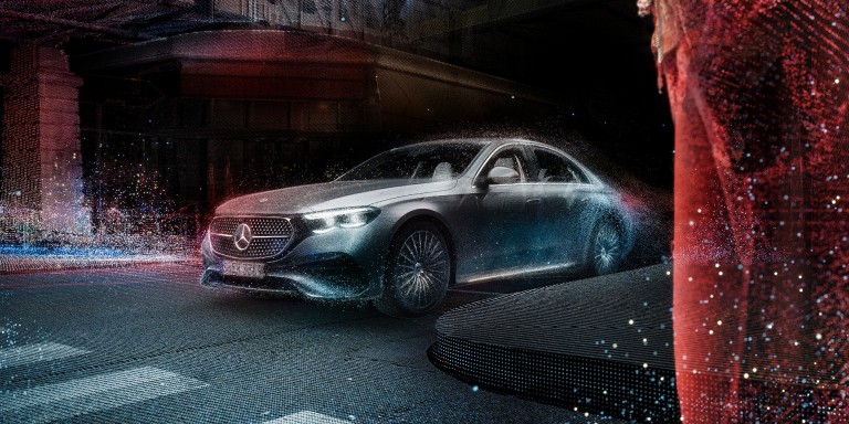 
				Eine stilisierte Version der Mercedes-Benz E-Klasse, die durch den Regen auf einer Strae fhrt.
				