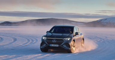 
						  Ein EQS SUV von links vorne, der ber eine verschneite Strae fhrt.
						  