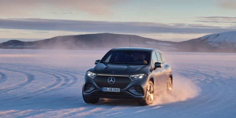 
				Ein EQS SUV von links vorne, der ber eine verschneite Strae fhrt.
				
