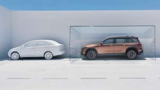 
Ein Mercedes-Benz SUV in einem Glaskasten neben einem weien Auto ohne Glaskasten.

