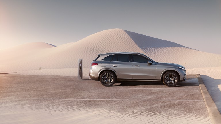 
			Ein GLC als Plug-in-Hybrid von Mercedes-Benz in mojavesilber metallic tankt an einer Ladesäule auf einem Parkplatz mitten in der Wüste.
		