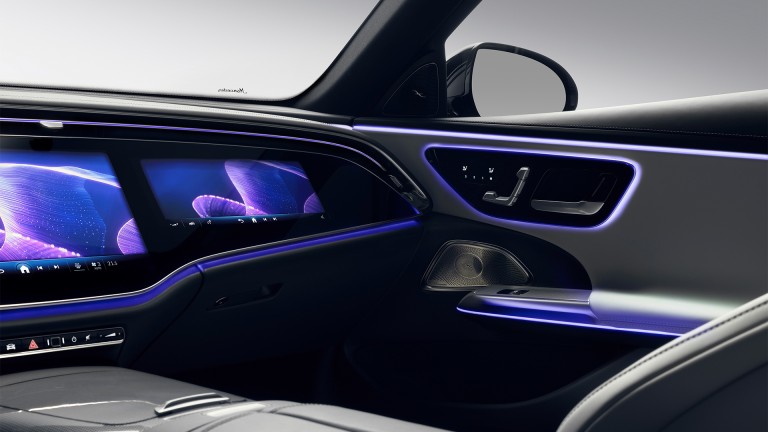 
			Blick auf den optionalen Superscreen mit zusätzlichem Display auf der Beifahrerseite. Neben der violetten Ambientebeleuchtung zeigen die abstrakten Abbildungen auf dem Beifahrerdisplay das Komfortprogramm „Behaglichkeit“.
		