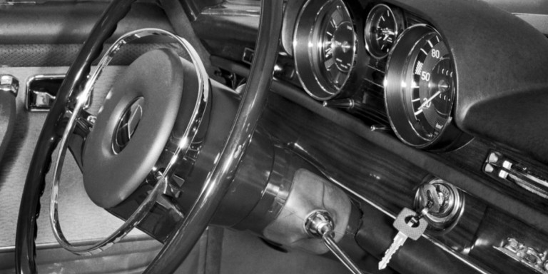 
				Nahaufnahme des Cockpits eines Mercedes-Benz Fahrzeugs Typ 250 S / SE beziehungsweise 300 SE / SEL aus dem Jahre 1965, im Zndschloss rechts neben dem Lenkrad am Armaturenbrett steckt der Zndschlssel.
				