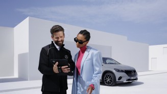 
Ein Mercedes-Benz Wartungsmitarbeiter zeigt einer Frau im blauen Blazer etwas auf einem Tablet, das er in der Hand hlt. Im Hintergrund steht ein EQE SUV in MANUFAKTUR alpingrau uni.
