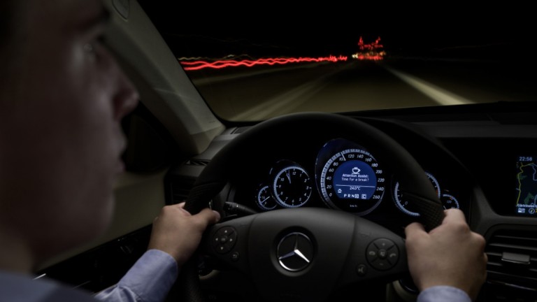 
			Eine Person sitzt bei einer Nachtfahrt am Steuer, whrend auf dem Display am Kombiinstrument durch das optionale ATTENTION ASSIST eine Pause vorgeschlagen wird.
		
