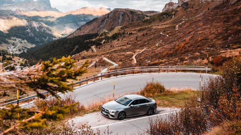 
			Eine A-Klasse Limousine in hightech silber metallic parkt auf einem Seitenstreifen inmitten einer italienischen Berglandschaft.
		
