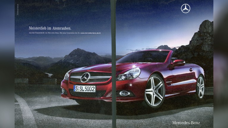 
			Eine 2008 Werbeanzeige, auf der ein roter Mercedes-Benz SL vor einer Berglandschaft steht, links oben ist der Slogan „Meisterdieb im Atemrauben“ zu lesen ist.
		