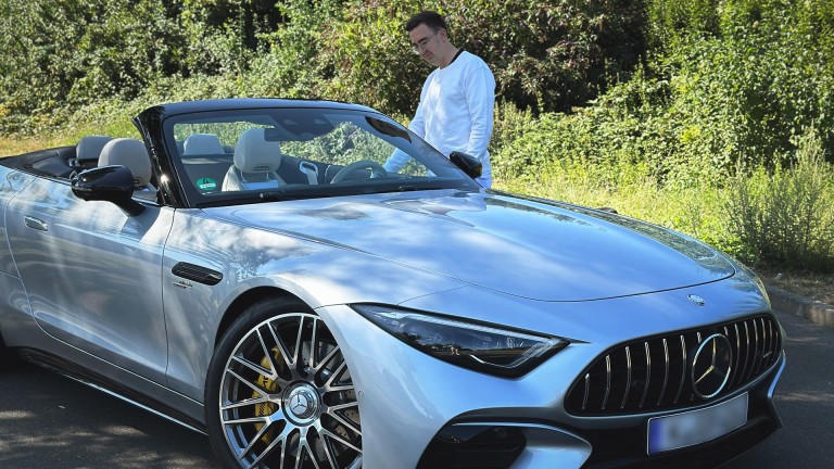 
			Barrierefreiheit: Marlon Hontheim steigt auf der Fahrerseite seines silbernen Mercedes-AMG SL 43 Roadster ein, der im Grnen geparkt ist.
		