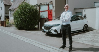 
						  Mercedes-Benz Produkttrainer Christoph Geissler steht vor einem Einfamilienhaus und verschrnkt lchelnd die Arme. Hinter ihm parkt ein Mercedes-AMG EQE 43 SUV in MANUFAKTUR opalithwei bright.
						  