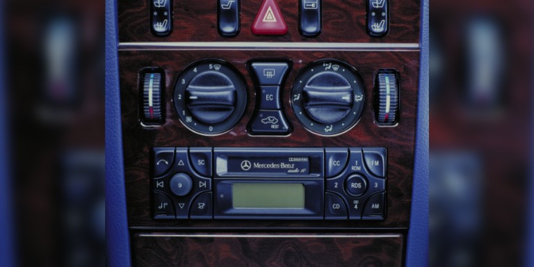 
				Nahaufnahme eines Autoradios in der Mercedes-Benz E-Klasse der Baureihe 210 von 1999 mit Kassettenlaufwerk.
				
