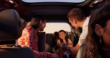
						  Blick in den Innenraum eines EQB: vorne rechts ist die Fahrerin zu sehen, dahinter sitzen eine Frau und ein Mann, die ein Kind ansehen, das lachend im Kindersitz auf der Rckbank sitzt.
						  